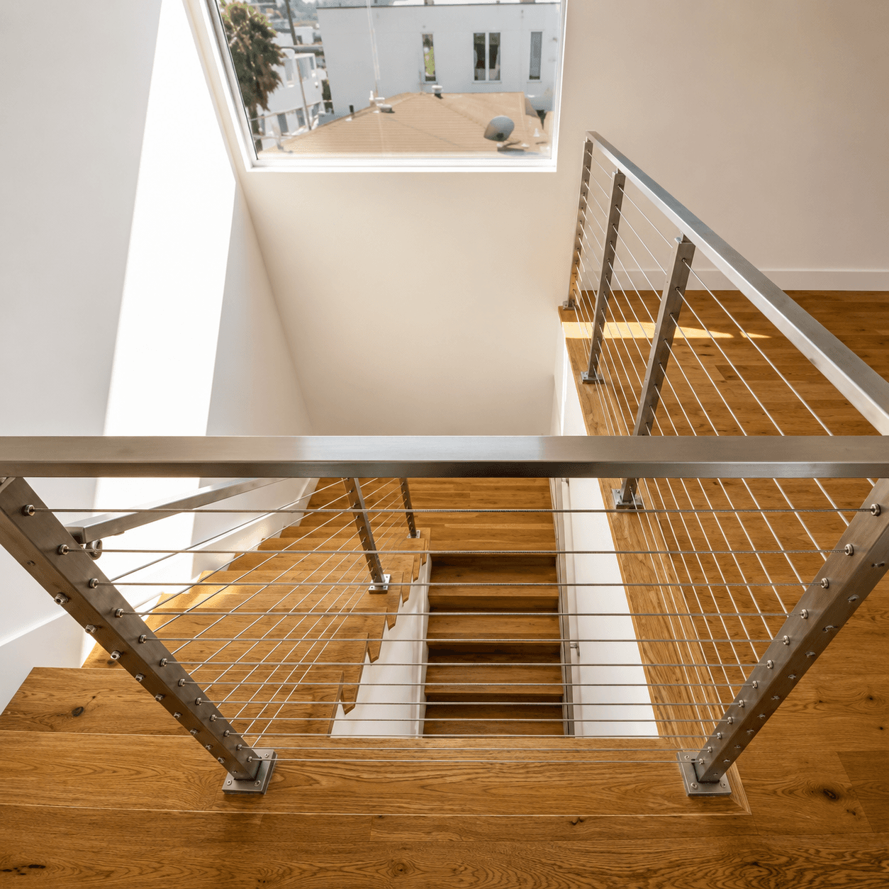 Stainless cable railing on a wood stair landing viewed from above