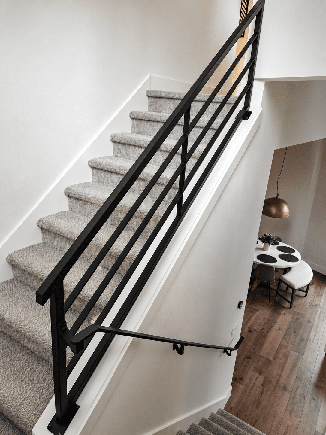Custom black horizontal-bar stair railing over a dining area