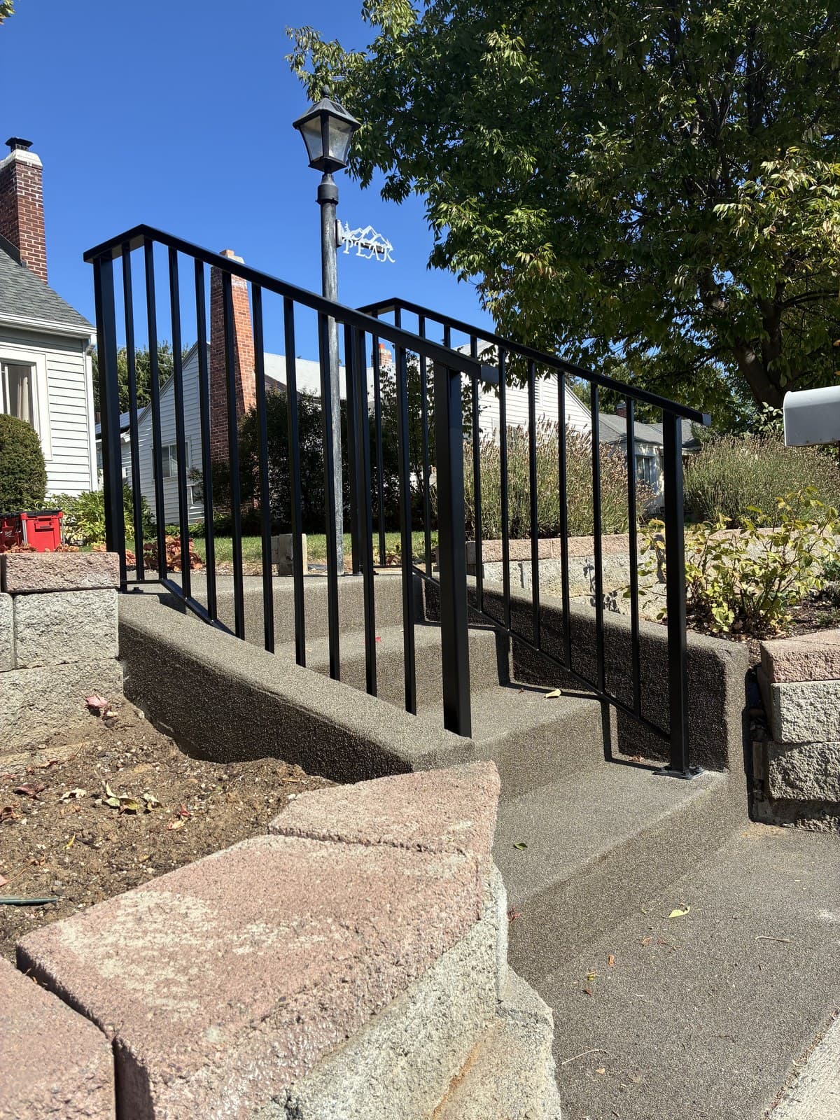 Custom black metal railing on concrete entry steps