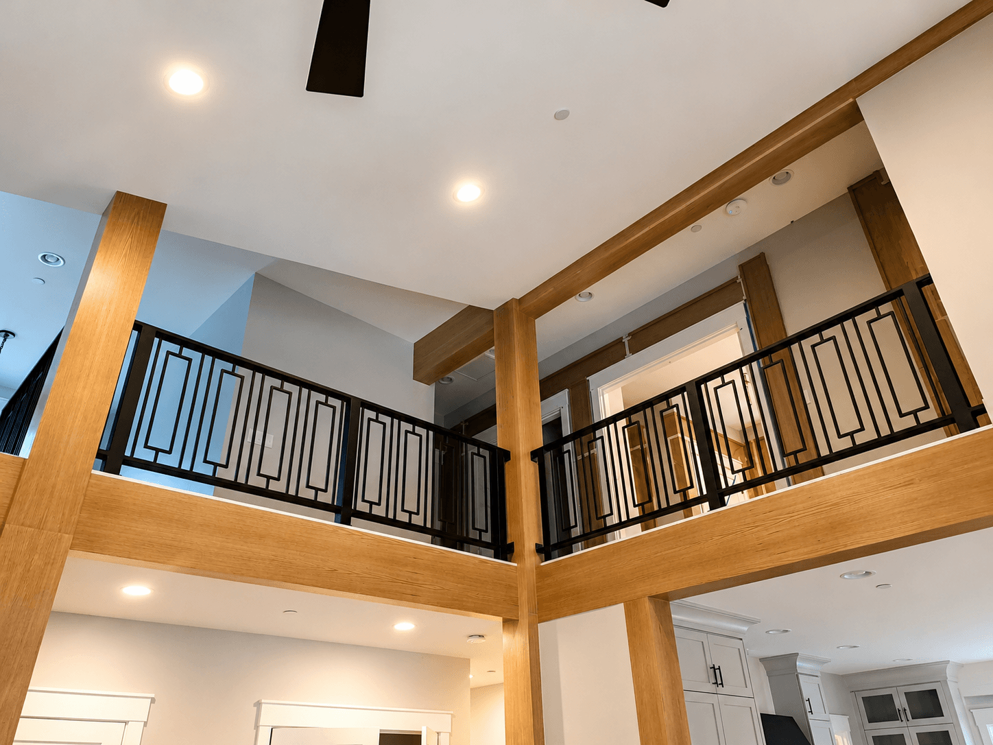 Custom geometric black metal railing on an interior loft landing