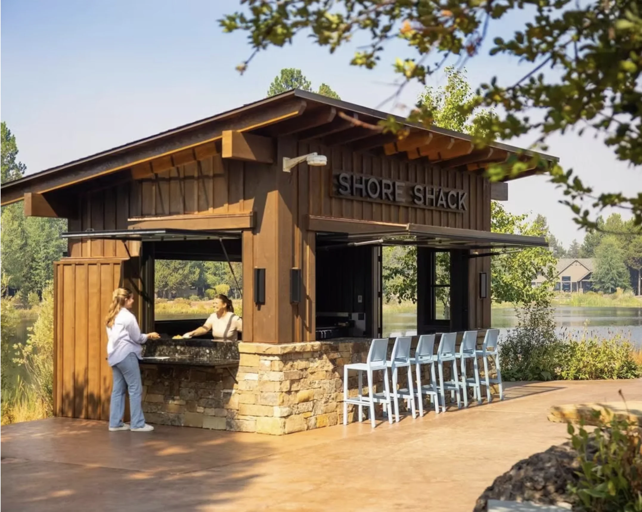 Pass-through windows opened on an outdoor lakeside kitchen